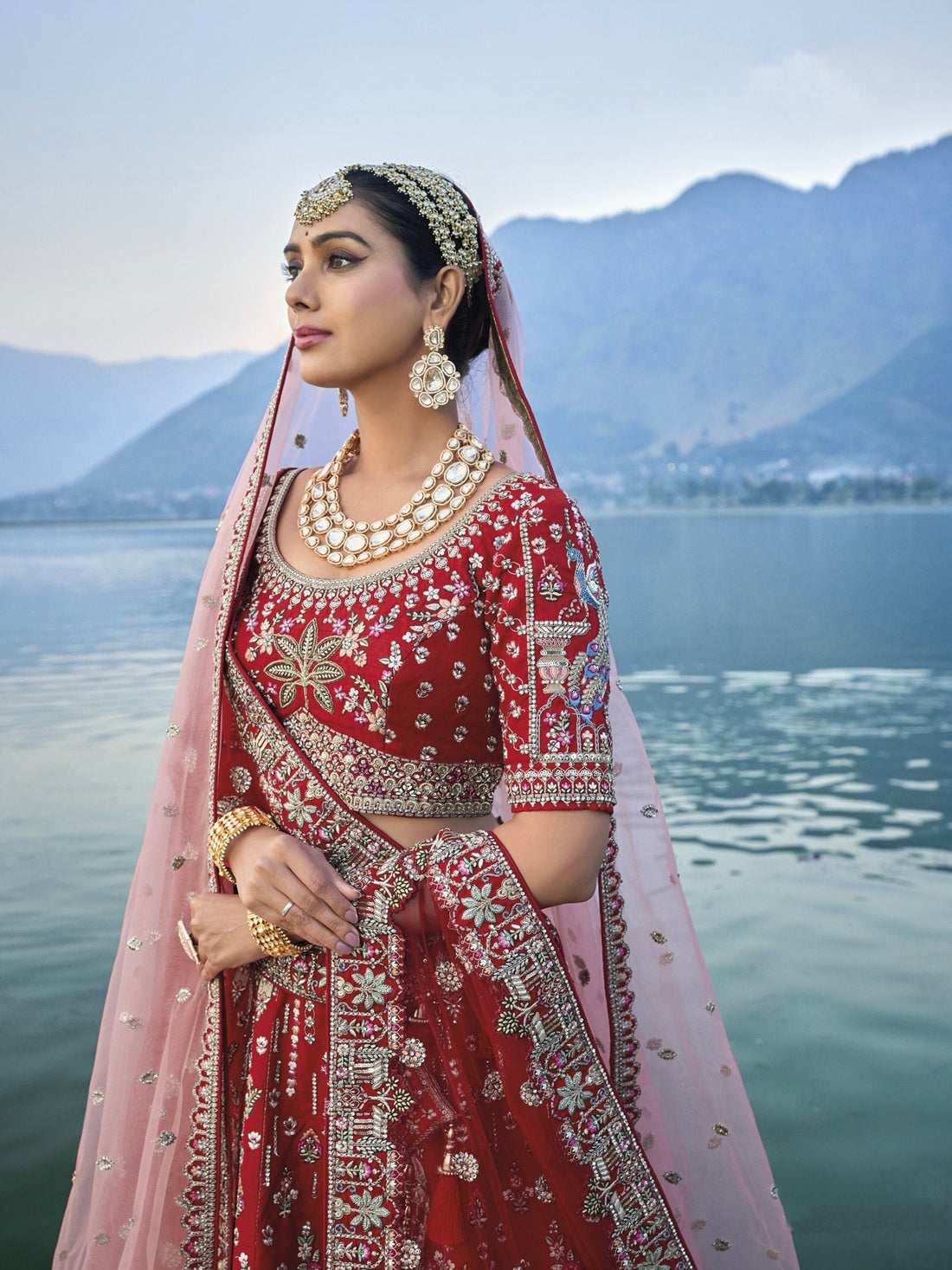 Exquisite red silk bridal lehenga with intricate embroidery and heavy net dupatta.