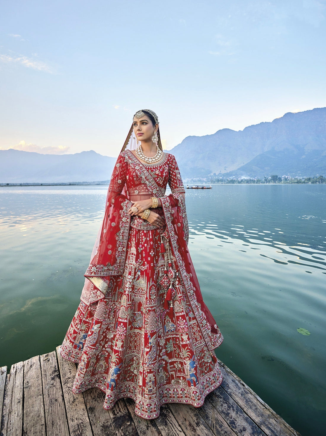 Exquisite red silk bridal lehenga with intricate embroidery and heavy net dupatta.