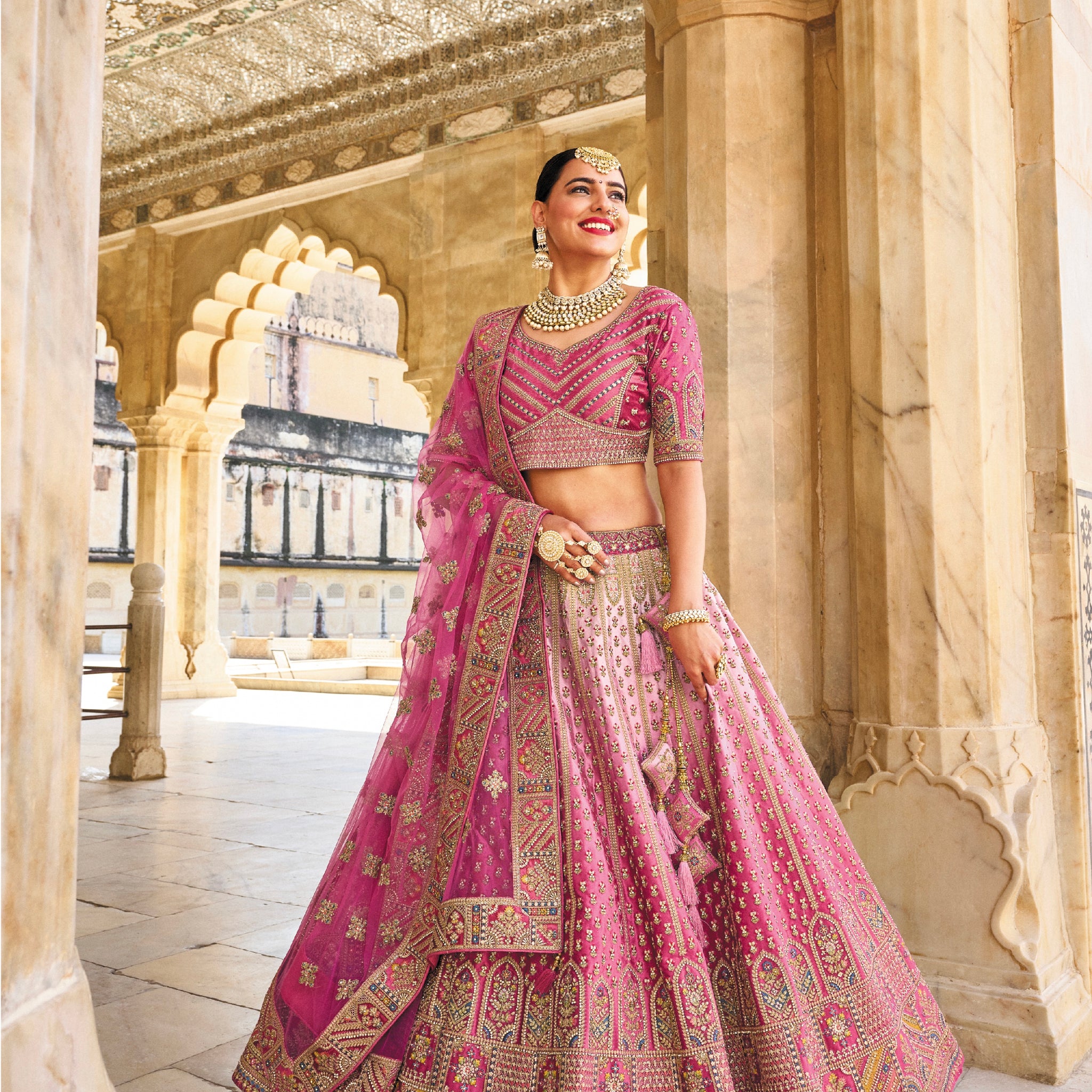 Elegant pink velvet lehenga with intricate embroidery and net dupatta.