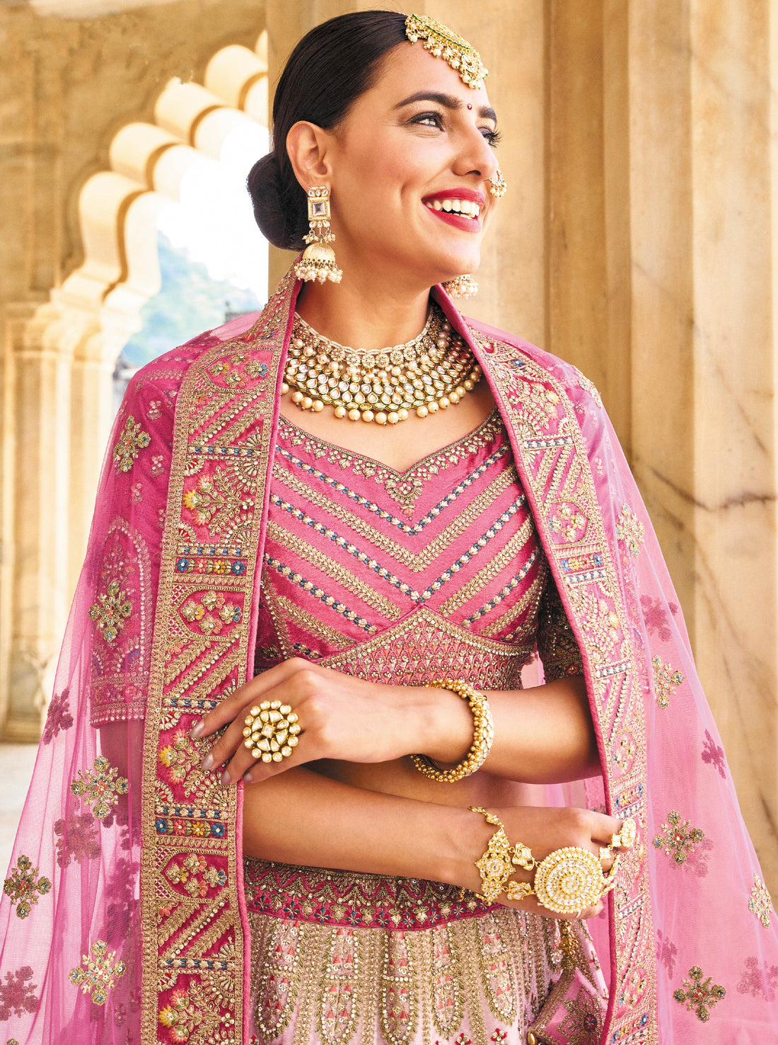 Elegant pink velvet lehenga with intricate embroidery and net dupatta.