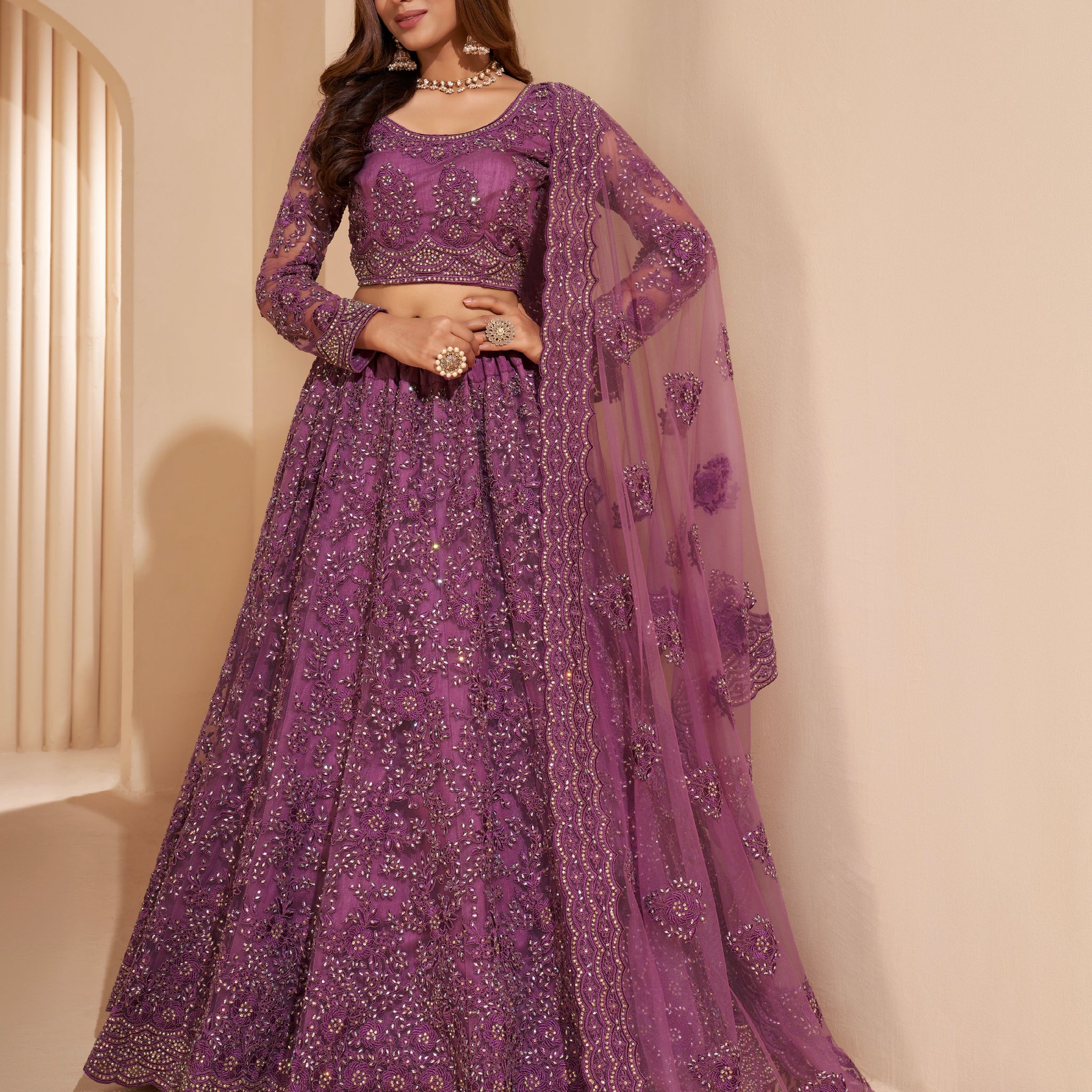 Elegant dark orchid net lehenga with silk inner and thread & cording embroidery.