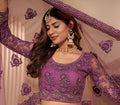 Elegant dark orchid net lehenga with silk inner and thread & cording embroidery.