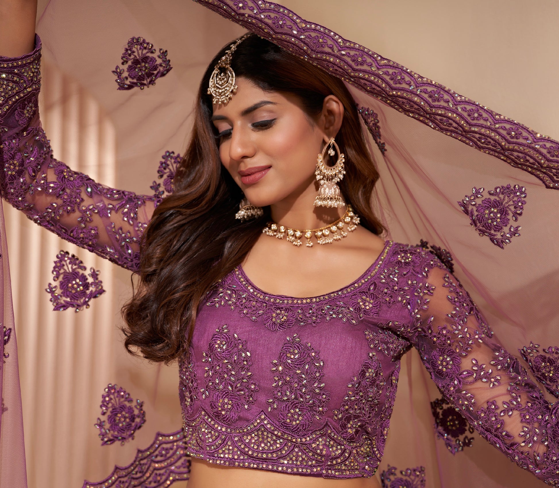 Elegant dark orchid net lehenga with silk inner and thread & cording embroidery.