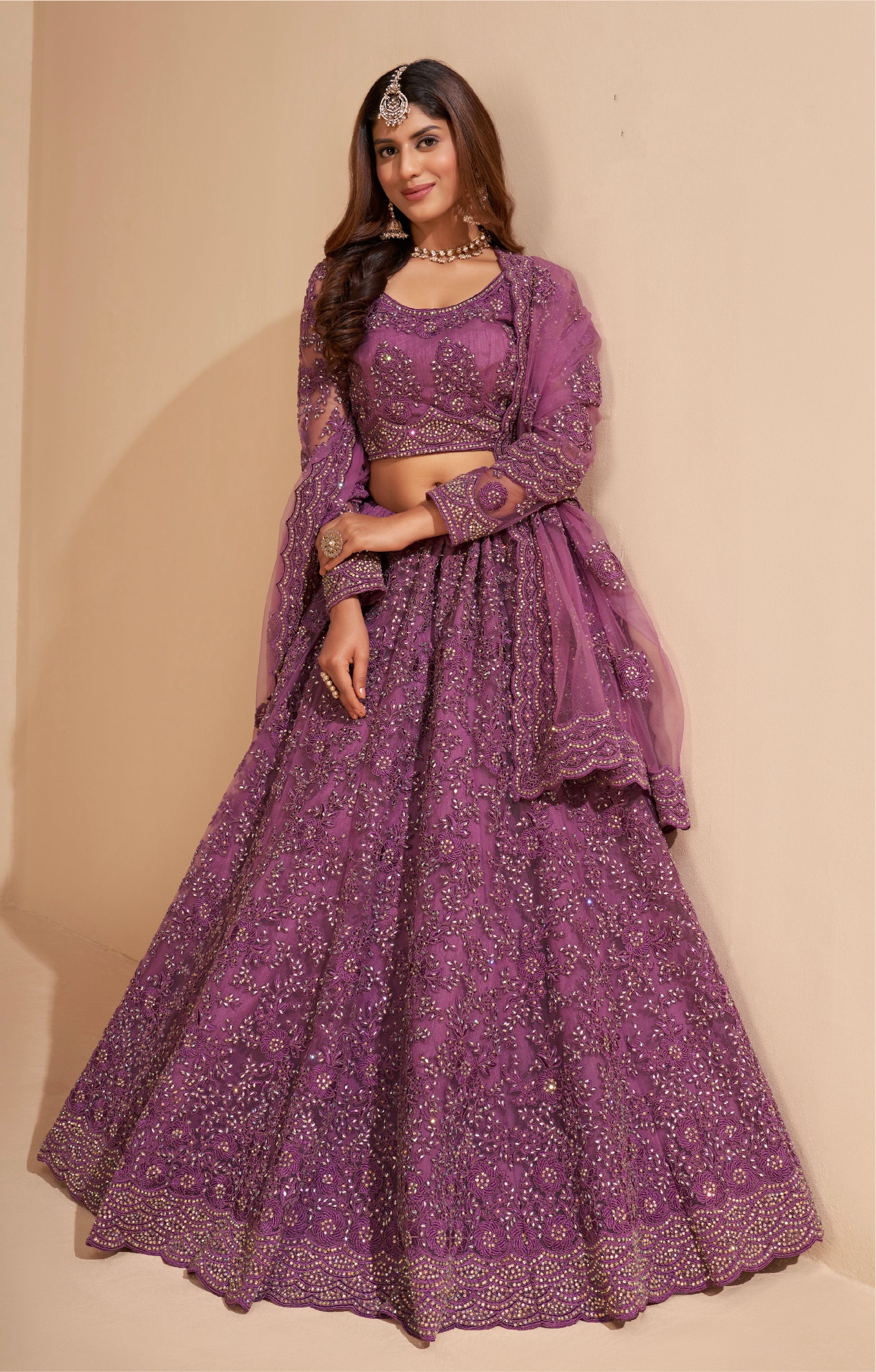 Elegant dark orchid net lehenga with silk inner and thread & cording embroidery.