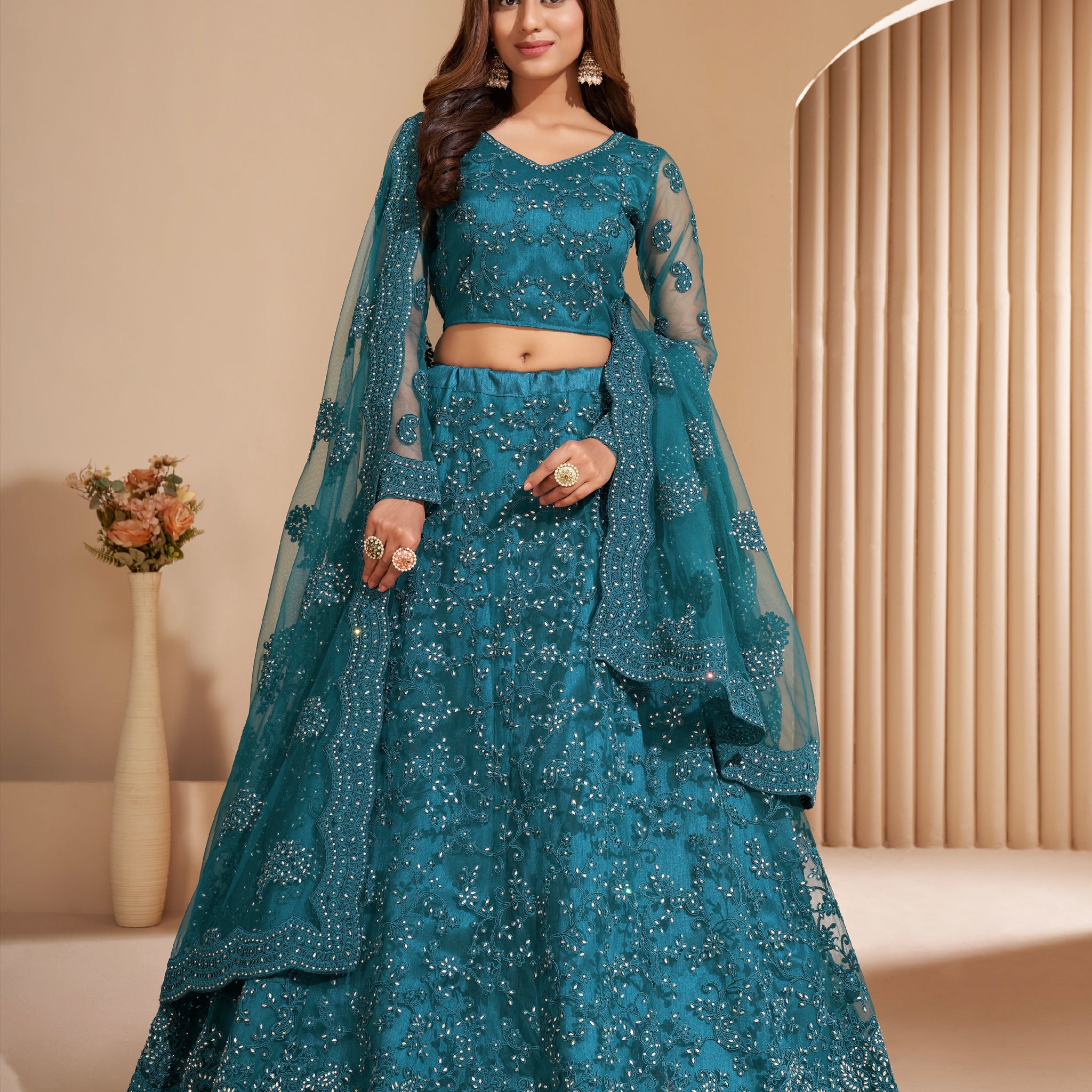 Elegant teal net lehenga with silk inner and thread & cording embroidery.