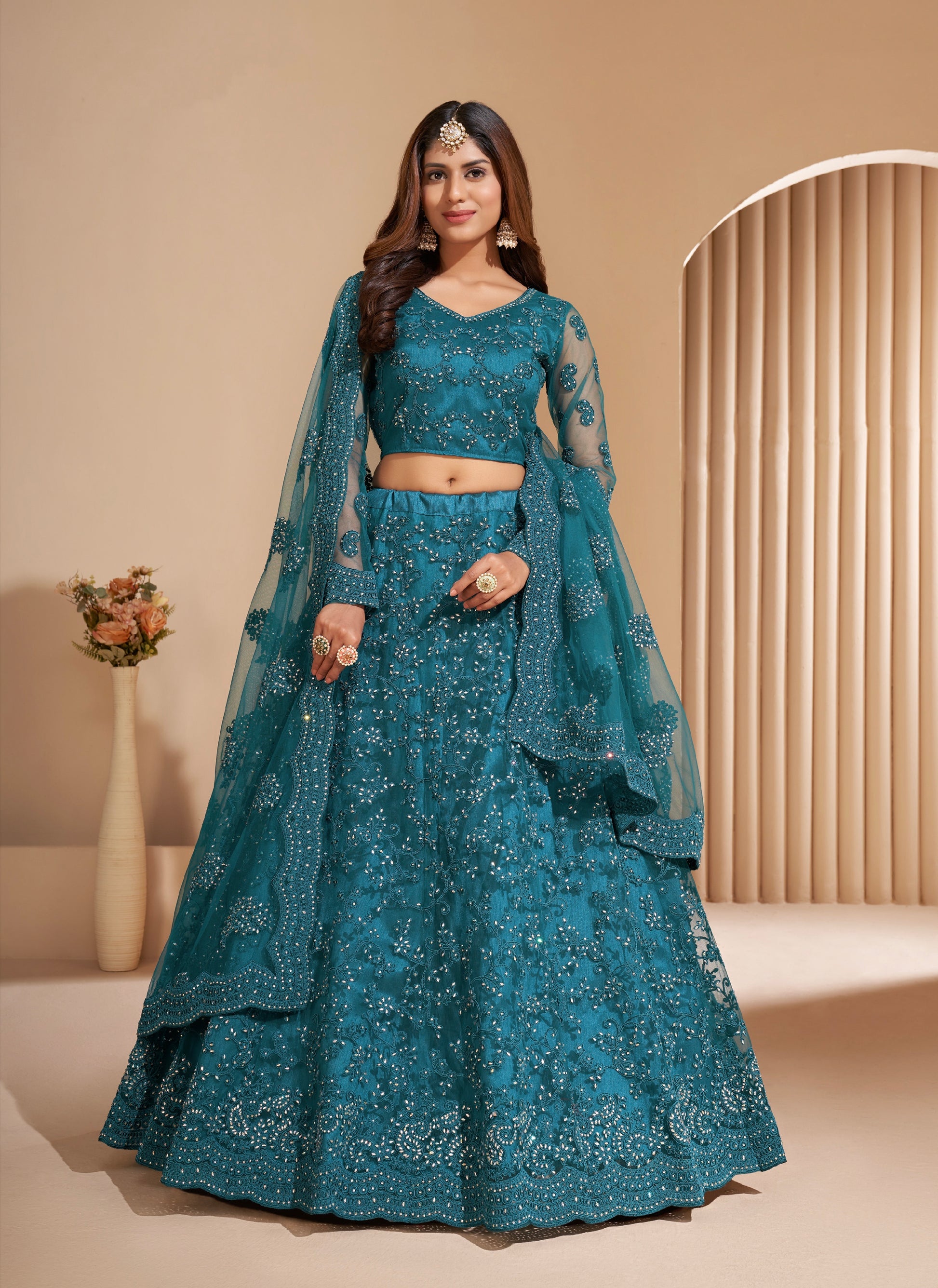 Elegant teal net lehenga with silk inner and thread & cording embroidery.