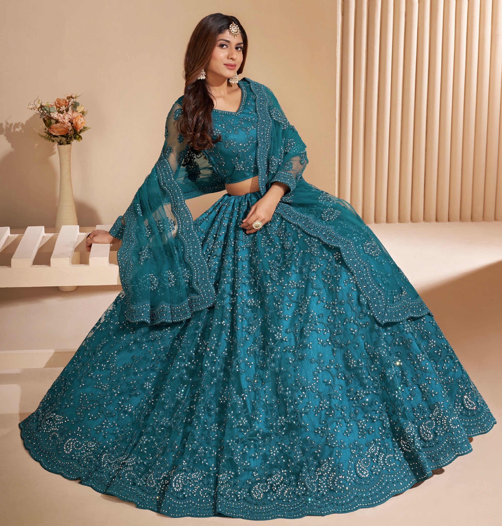 Elegant teal net lehenga with silk inner and thread & cording embroidery.