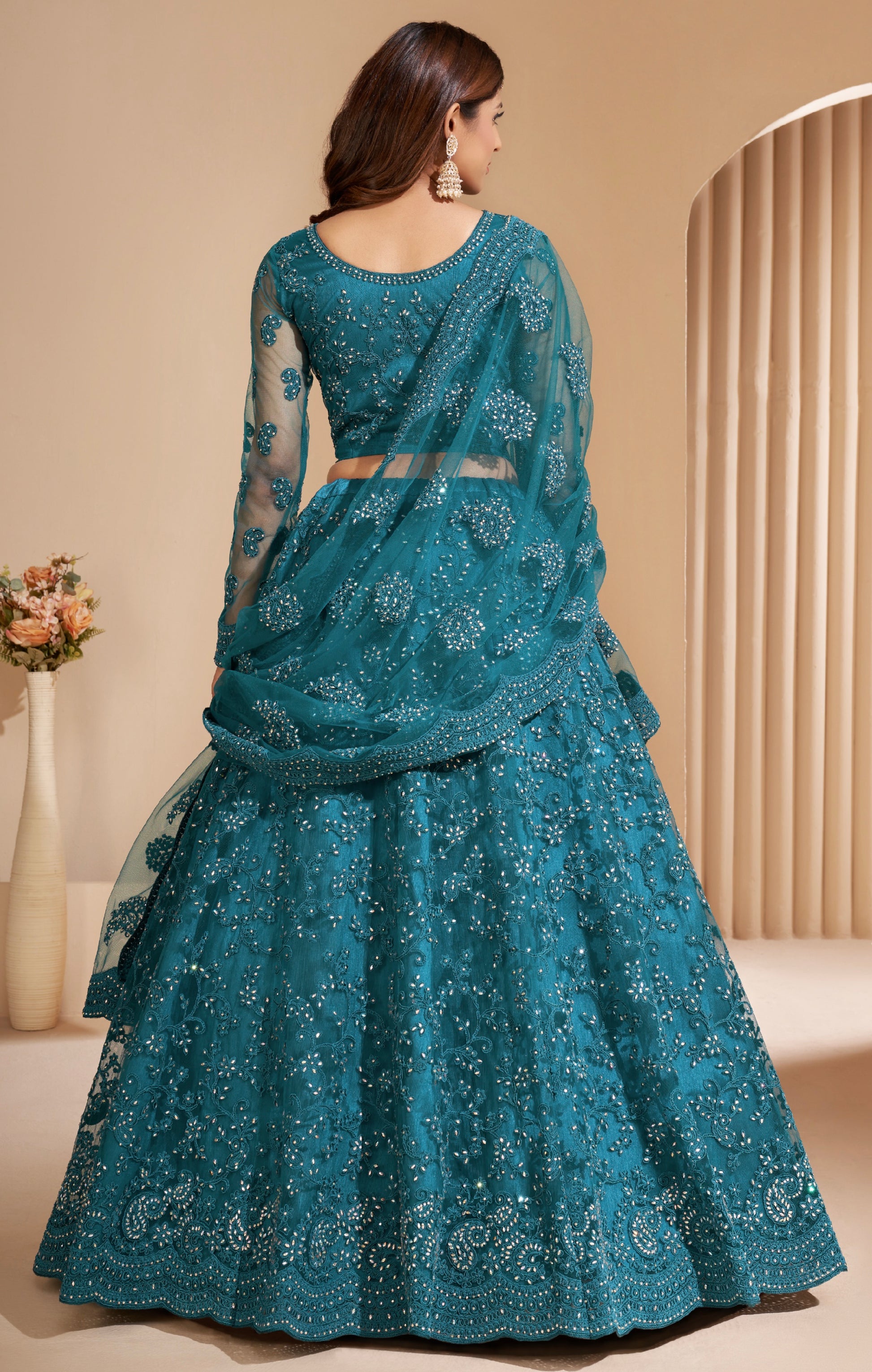 Elegant teal net lehenga with silk inner and thread & cording embroidery.