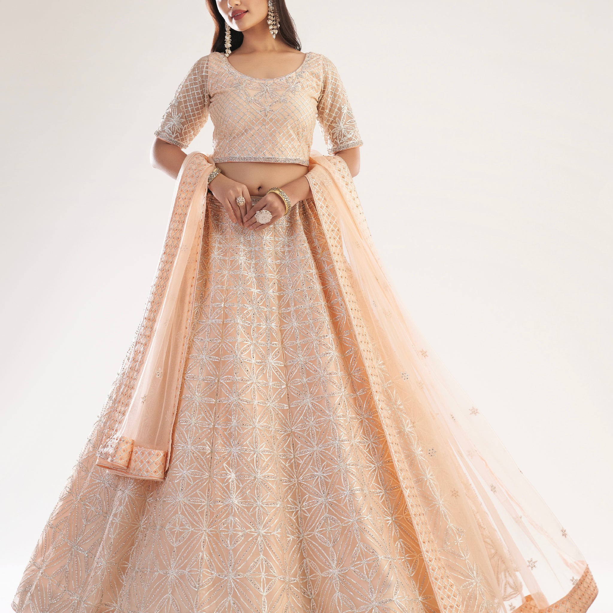 Elegant peach bridal lehenga with ribbon gota work and heavy zarkan embellishments.