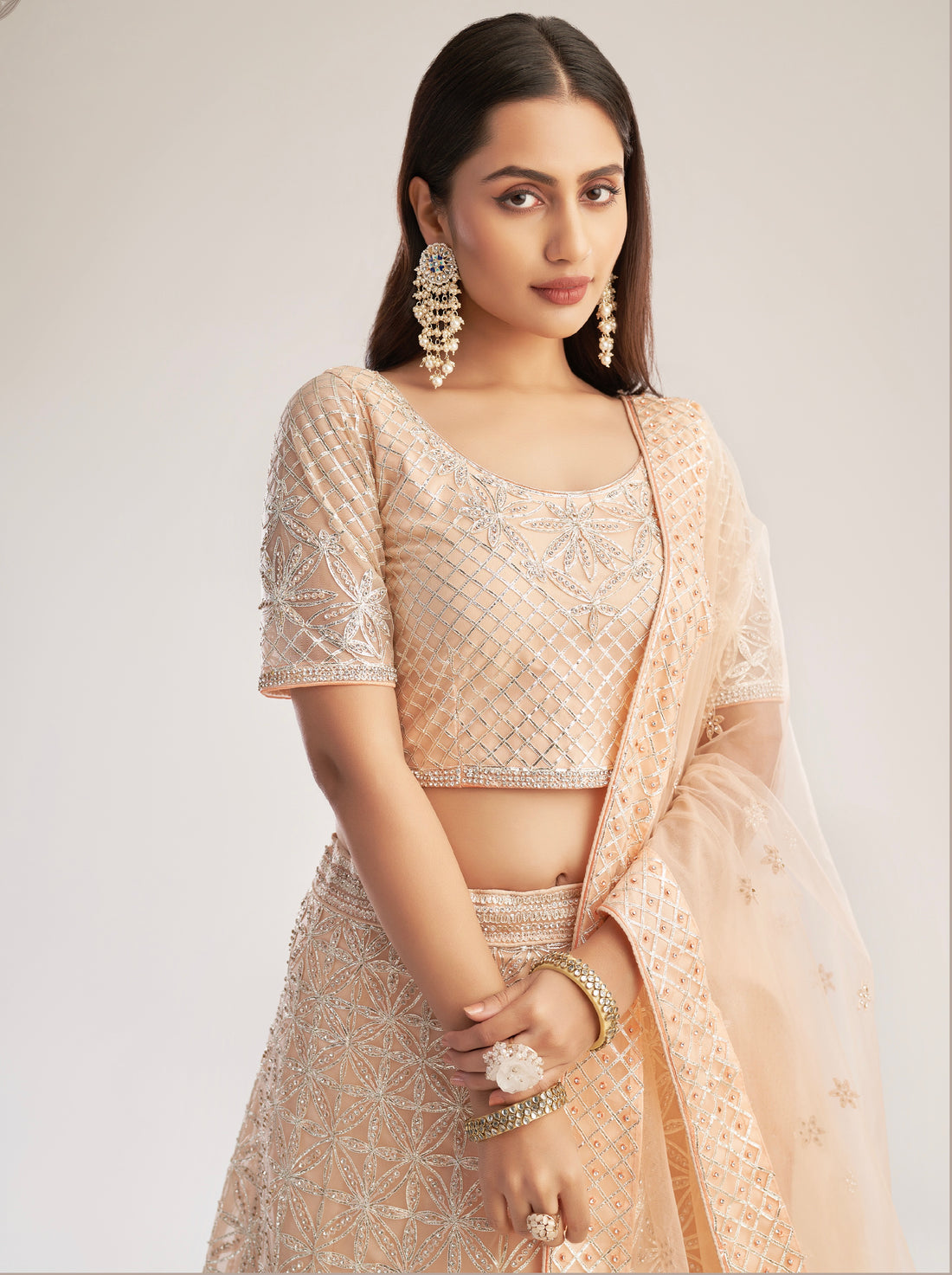 Elegant peach bridal lehenga with ribbon gota work and heavy zarkan embellishments.