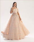 Elegant peach bridal lehenga with ribbon gota work and heavy zarkan embellishments.