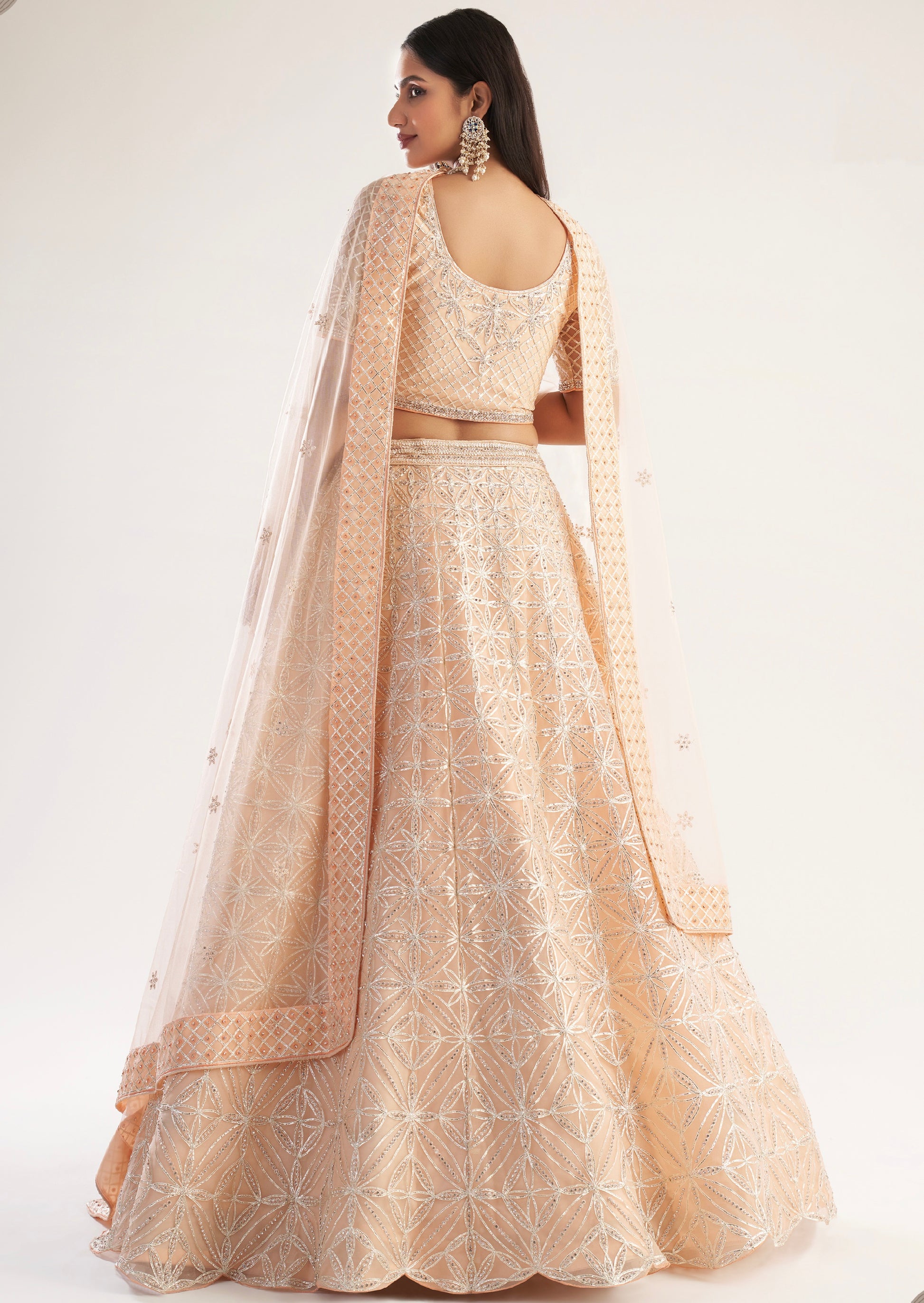 Elegant peach bridal lehenga with ribbon gota work and heavy zarkan embellishments.