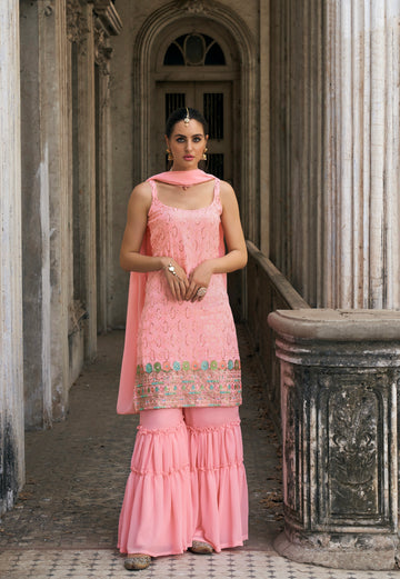 Woman in pink embroidered georgette sharara suit with dupatta.